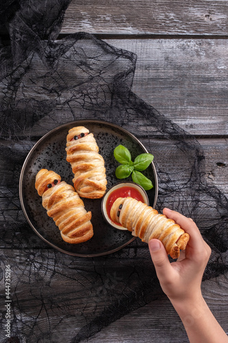 Scary sausage mummies in dough with funny eyes. Halloween food.