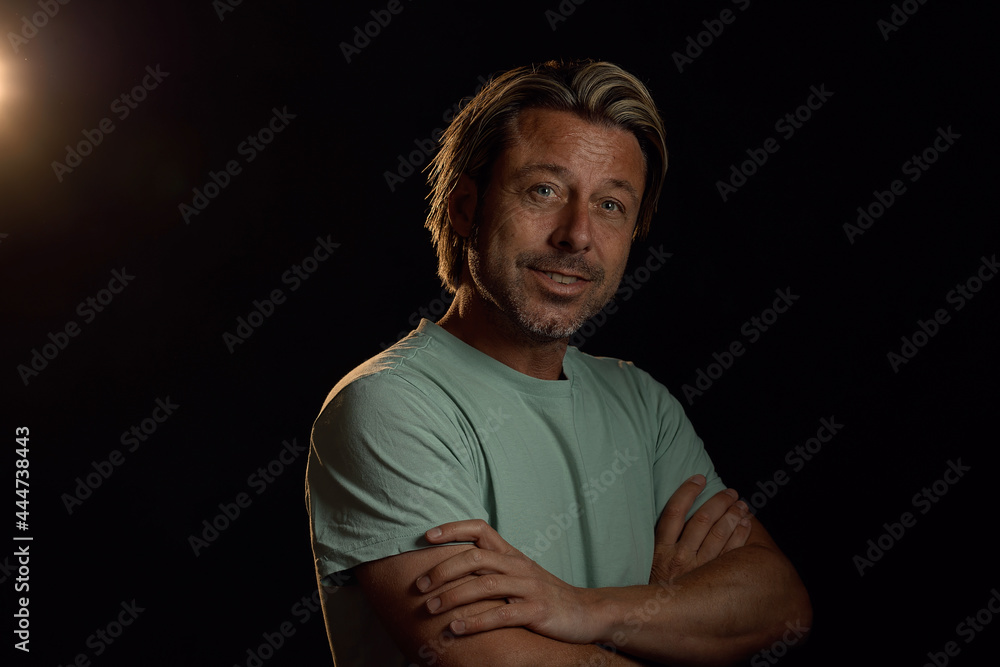 Naklejka premium Smiling man with blonde hair and a stubble beard in a light green t-shirt.
