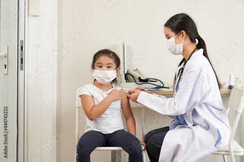 Vaccination process with doctor will inject to asian girl in hospital for protection of covid19