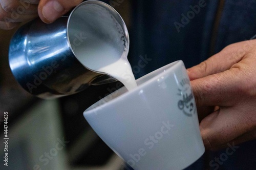 taza de café con espuma de leche recién hecho en máquina cafetera