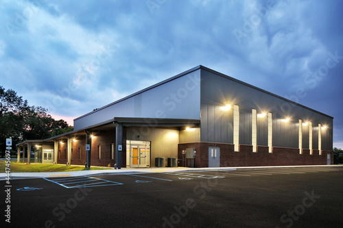 Exterior of large warehouse gym building at night