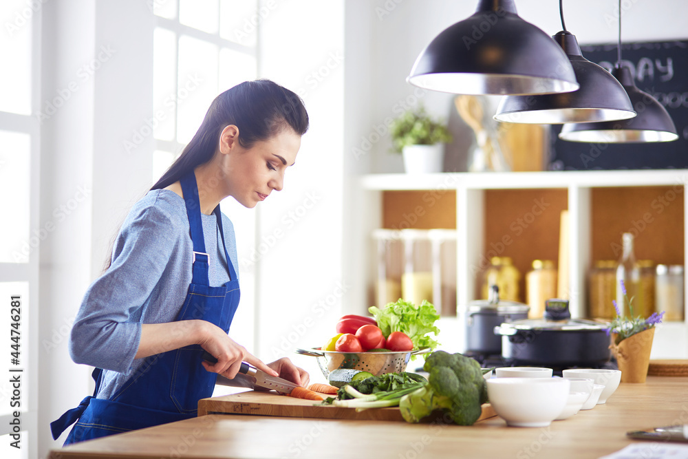 Young woman cutting vegetables in kitchen at home Young woman cutting vegetables in kitchen at home