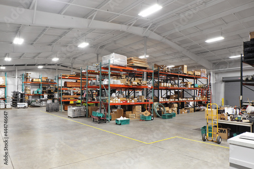 Shelves of boxes and merchandise in industrial warehouse packing distribution facility