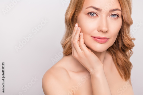 Cropped photo portrait woman naked shoulders hydrating anti age cream on cheek isolated white color background