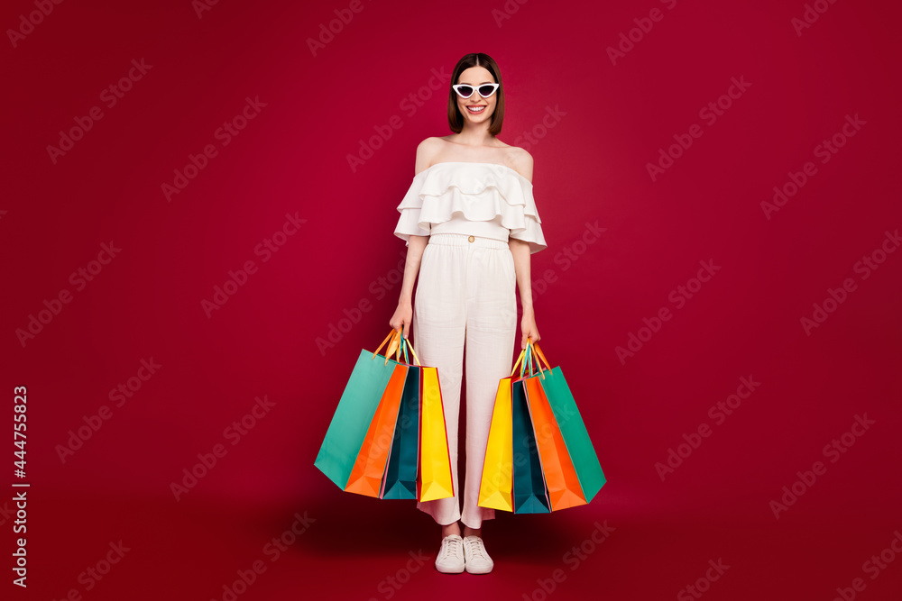 Full length photo of nice brown hairdo young lady with bags wear eyewear top pants isolated on red background