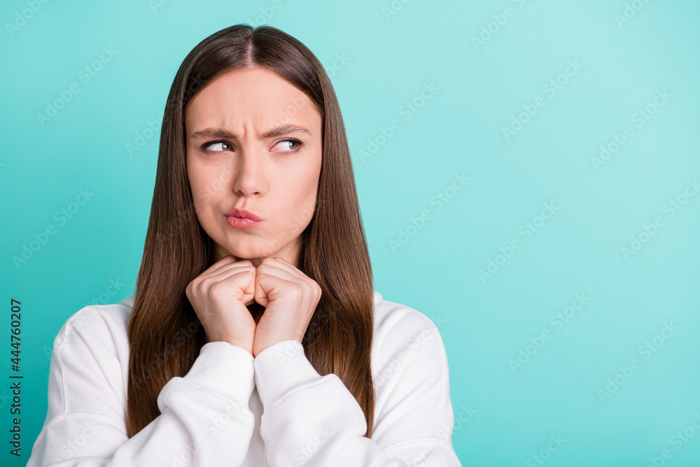 Photo of sweet doubtful young lady wear white sweatshirt arms chin looking empty space isolated turquioise color background Photo of sweet doubtful young lady wear white sweatshirt arms chin looking empty space isolated turquioise color background