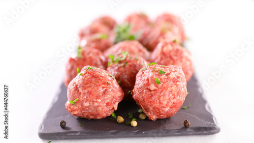 raw meatballs with parsley on white background