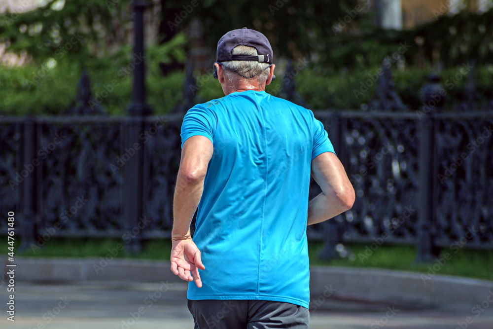 Fototapeta premium A man runs along the city embankment