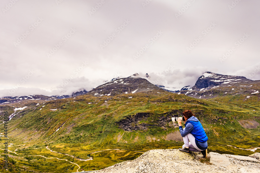 Naklejka premium Tourist with camera in Norway mountains