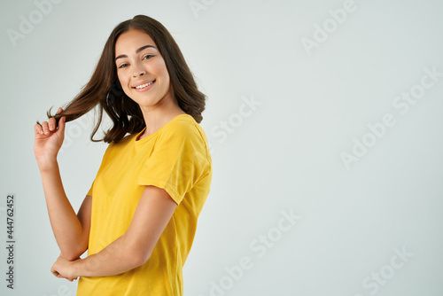 woman in yellow t-shirt holding hair fashion hairstyle smile cropped view