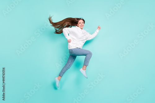 Fototapeta Naklejka Na Ścianę i Meble -  Full length body size view of lovely cheerful successful girl jumping running isolated over bright teal turquoise color background