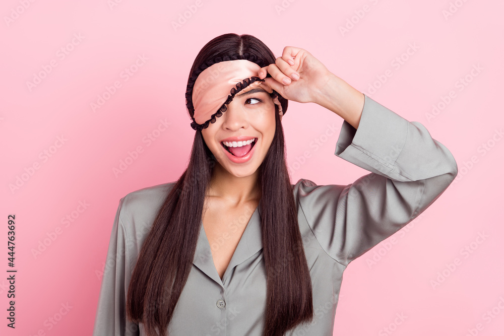 Portrait of attractive cheerful girl touching blindfold waking up peeking having fun party isolated over pink pastel color background