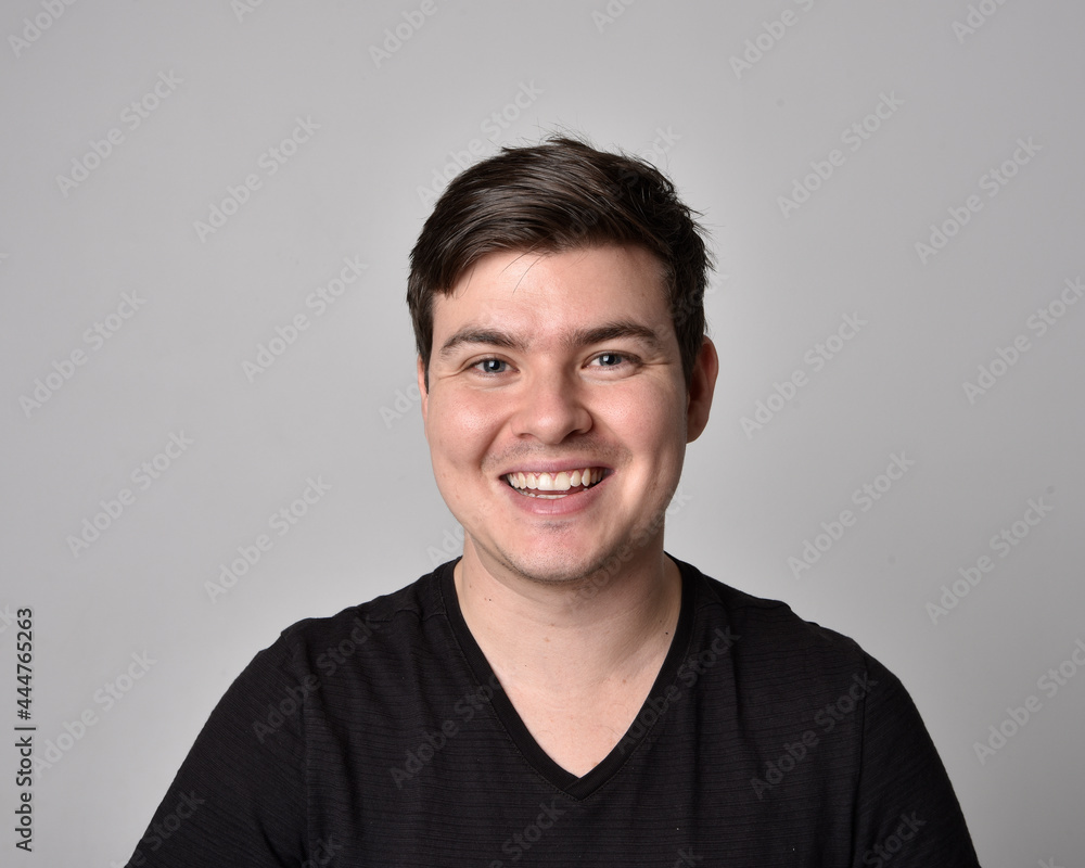 Close up head and shoulders portrait of a brunette. young man with a variety of expressive facial expressions. Isolated on a light grey studio background. Close up head and shoulders portrait of a brunette. young man with a variety of expressive facial expressions. Isolated on a light grey studio background.