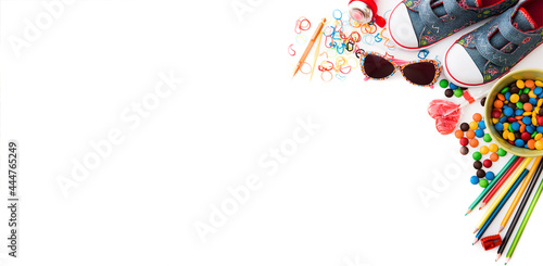 white backgrounnd with colourful kids's sweets and stationery with copyspace. Childhood concept.