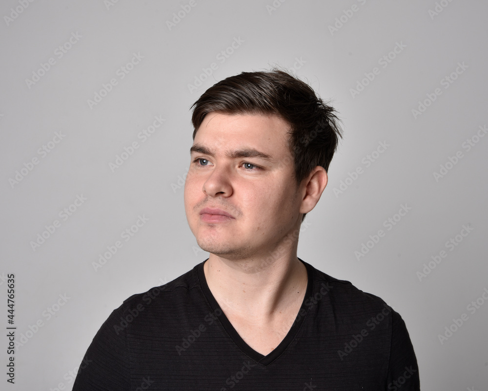 Obraz premium Close up head and shoulders portrait of a brunette. young man with a variety of expressive facial expressions. Isolated on a light grey studio background.