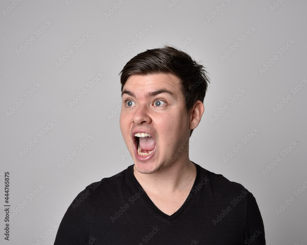 Close up head and shoulders portrait of a brunette. young man with a variety of expressive facial expressions. Isolated on a light grey studio background. Close up head and shoulders portrait of a brunette. young man with a variety of expressive facial expressions. Isolated on a light grey studio background.