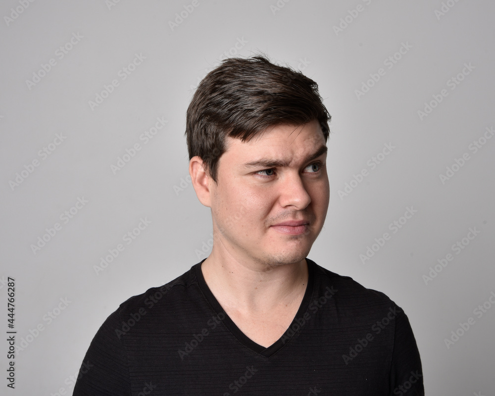 Close up head and shoulders portrait of a brunette. young man with a variety of expressive facial expressions. Isolated on a light grey studio background. Close up head and shoulders portrait of a brunette. young man with a variety of expressive facial expressions. Isolated on a light grey studio background.
