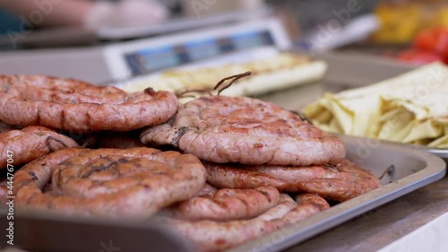 Wallpaper Mural Grilled Sausages Baked on the Grill are Sold on an Outdoor Street Showcase. B-B-Q. Sale of Fried juicy barbecue from meat roll. Juicy, fresh fast food on the counter, cut pieces. 4K. Slow-motion. Torontodigital.ca