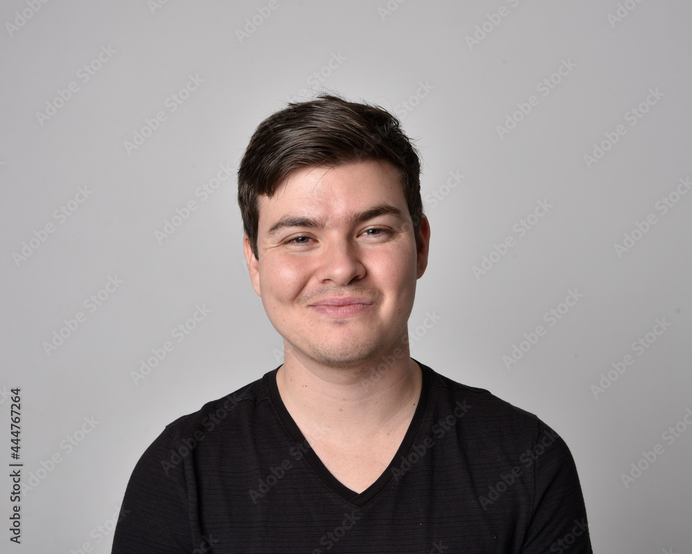 Close up head and shoulders portrait of a brunette. young man with a variety of expressive facial expressions. Isolated on a light grey studio background. Close up head and shoulders portrait of a brunette. young man with a variety of expressive facial expressions. Isolated on a light grey studio background.