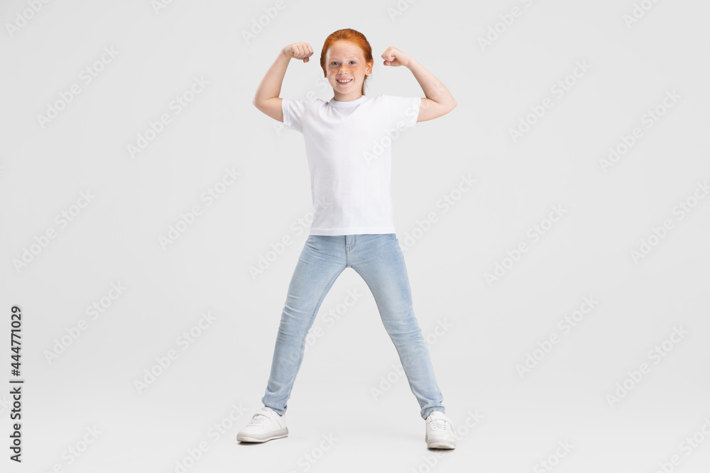 Beautiful cute little red-headed girl in casual outfit having fun isolated on white studio background. Happy childhood concept. Sunny child Beautiful cute little red-headed girl in casual outfit having fun isolated on white studio background. Happy childhood concept. Sunny child