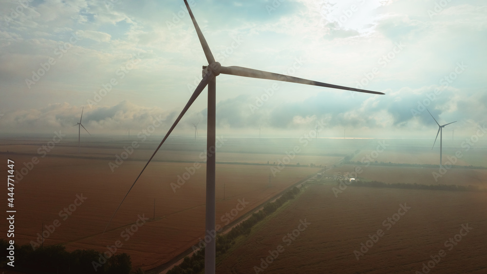Fototapeta premium Eco Energy Concept with Wind Turbine Close-up in Low Cloudy