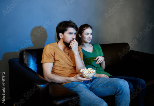 funny family sitting at home on the couch watching movies popcorn emotions
