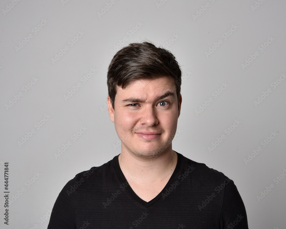 Close up head and shoulders portrait of a brunette. young man with a variety of expressive facial expressions. Isolated on a light grey studio background. Close up head and shoulders portrait of a brunette. young man with a variety of expressive facial expressions. Isolated on a light grey studio background.