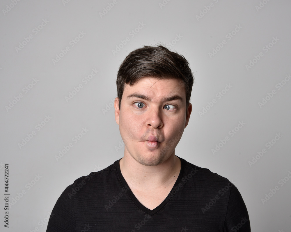 Obraz premium Close up head and shoulders portrait of a brunette. young man with a variety of expressive facial expressions. Isolated on a light grey studio background.