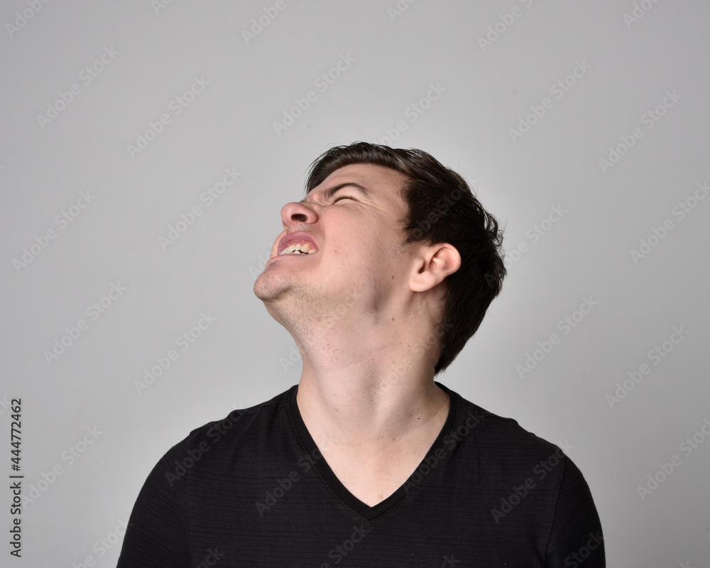 Close up head and shoulders portrait of a brunette. young man with a variety of expressive facial expressions. Isolated on a light grey studio background. Close up head and shoulders portrait of a brunette. young man with a variety of expressive facial expressions. Isolated on a light grey studio background.