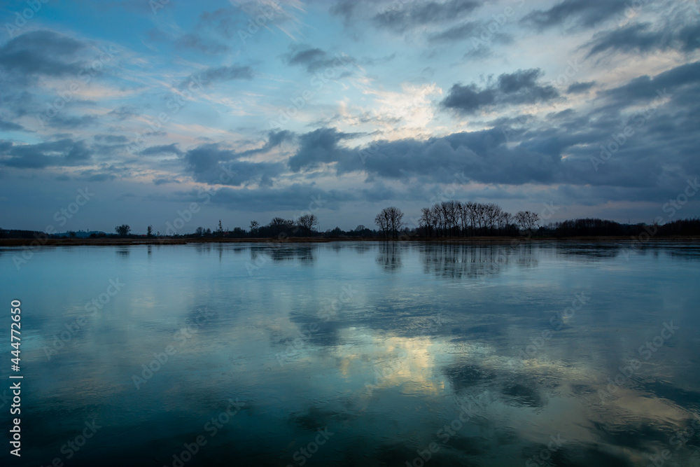 Reflection of evening clouds in a frozen lake