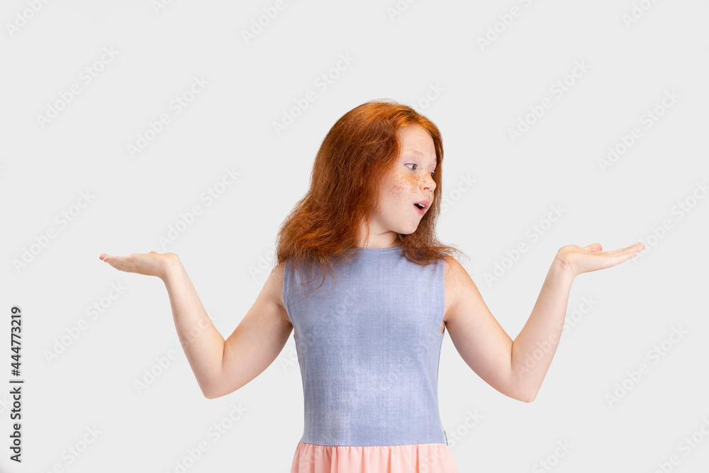 Beautiful cute little red-headed girl in casual outfit posing isolated on white studio background. Happy childhood concept. Sunny child Beautiful cute little red-headed girl in casual outfit posing isolated on white studio background. Happy childhood concept. Sunny child