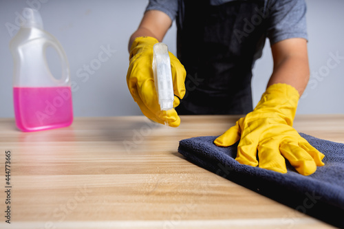 Close-up of cleaning man working in shop clean on wood table, protection coronavirus concept