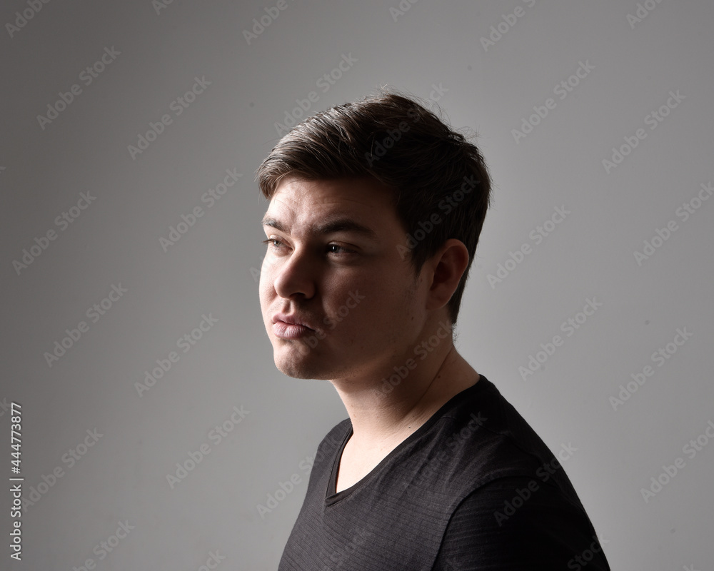 Close up head and shoulders portrait of a brunette. young man with a variety of expressive facial expressions. Isolated on a light grey studio background. Close up head and shoulders portrait of a brunette. young man with a variety of expressive facial expressions. Isolated on a light grey studio background.