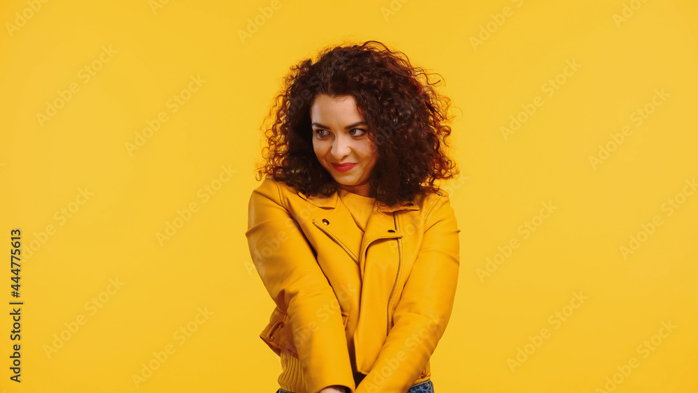 shy young woman in leather jacket isolated on yellow shy young woman in leather jacket isolated on yellow