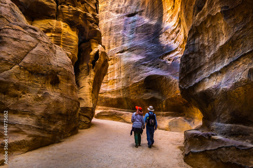 Group of people between sandstone rocks at narrow path in Petra, Jordan