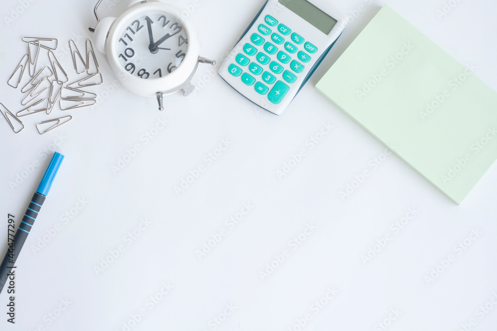 Workplace, clock, calculator, note paper, paper clips and pen on white background, copy space Workplace, clock, calculator, note paper, paper clips and pen on white background, copy space