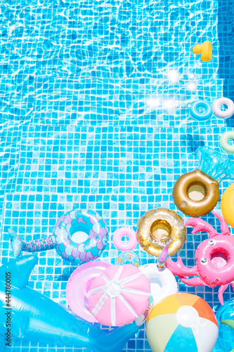 various inflatable on a pool water background. ball, crab, dolphin, float. summer and travel concept. copy space