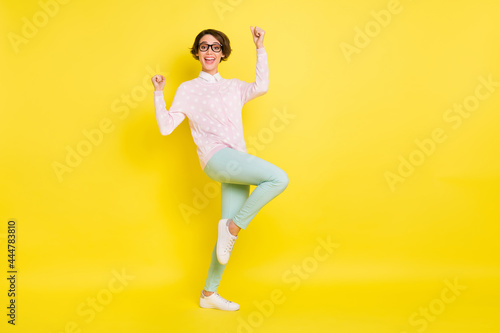 Full length photo of victorious young brown bob haired woman raise fists lucky win isolated on vivid yellow color background