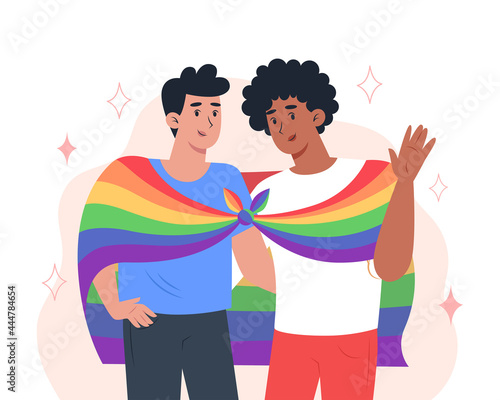 Young men couple hug each other and hold a rainbow LGBT pride flag