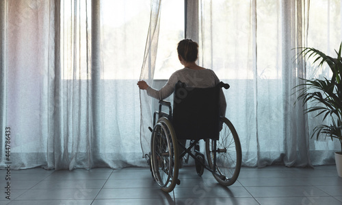 Foto Woman in wheelchair at home alone