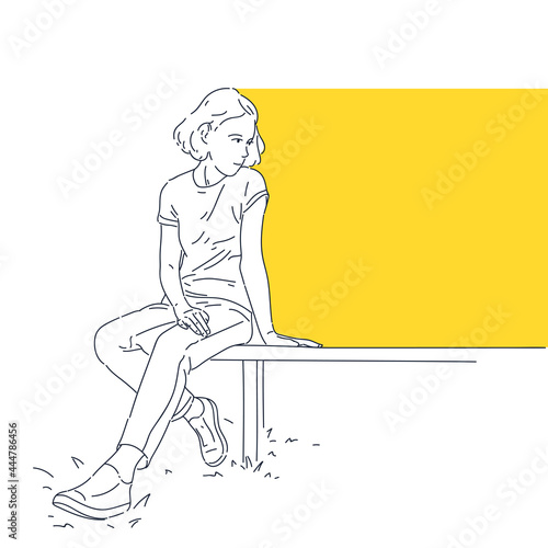 The girl is sitting on a bench. A template for placing information. A young girl in modern street clothes is resting.