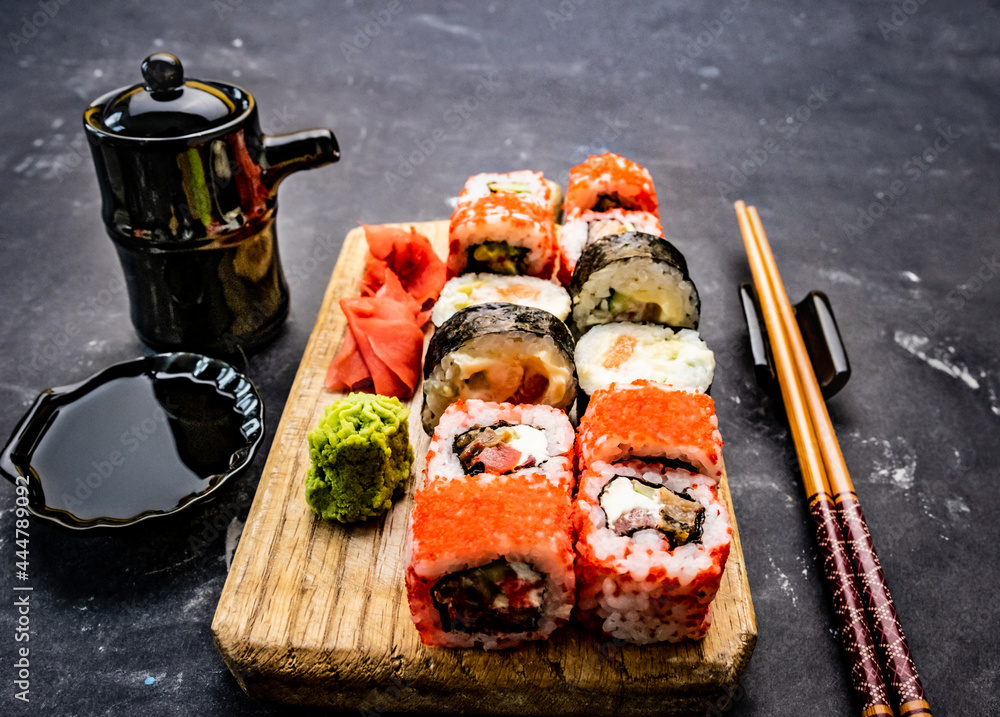 Oriental traditional sushi maki set served on wooden tablet with
