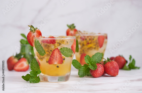 the passion fruit cocktail with mint and ice cubes in glass, homemade fresh fruit, passion and strawberry  sweet fruit drinks, fruit drink for healthy concept, selective focus.