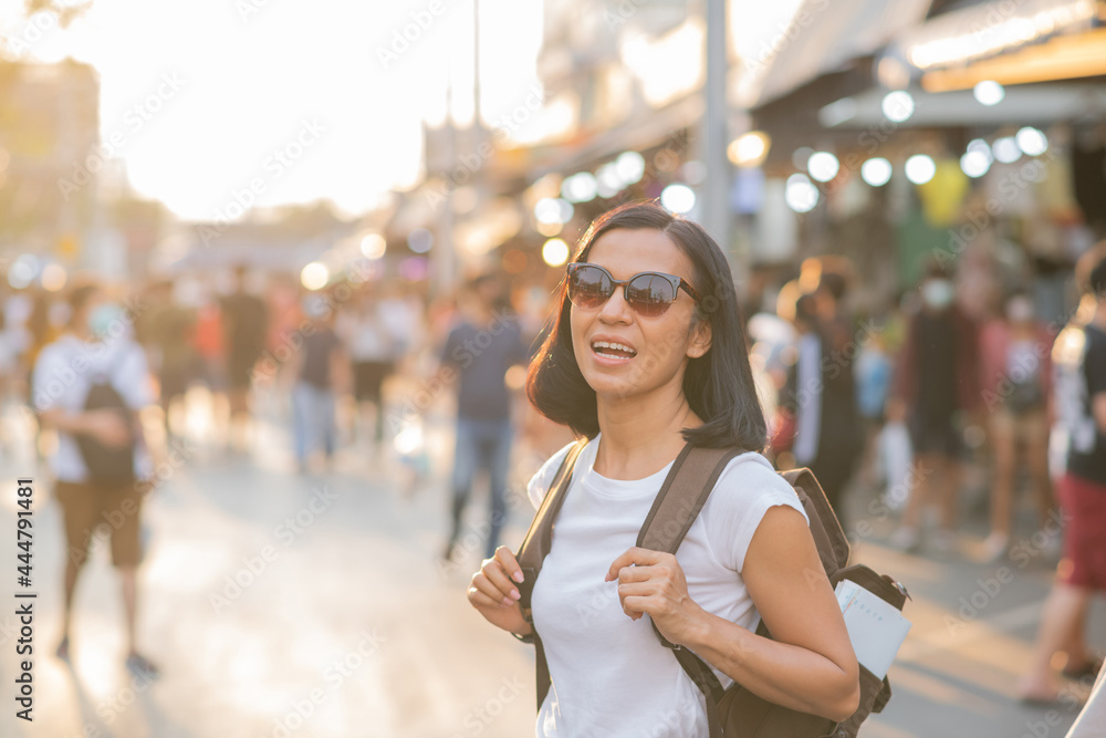Happy travel of woman in sunny city centre. Young joyful women expressing positivity, using map, vacation with bags, sunglasses, Shopping at street Chatuchak Weekend Market in Bangkok, Thailand Happy travel of woman in sunny city centre. Young joyful women expressing positivity, using map, vacation with bags, sunglasses, Shopping at street Chatuchak Weekend Market in Bangkok, Thailand