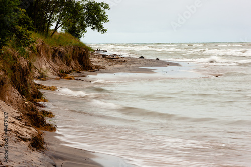 Fotografiet The eroding sand dune shoreline of Kohler-Andrae State Park, Sheboygan, Wisconsin due to the high water, and wave action of Lake Michigan
