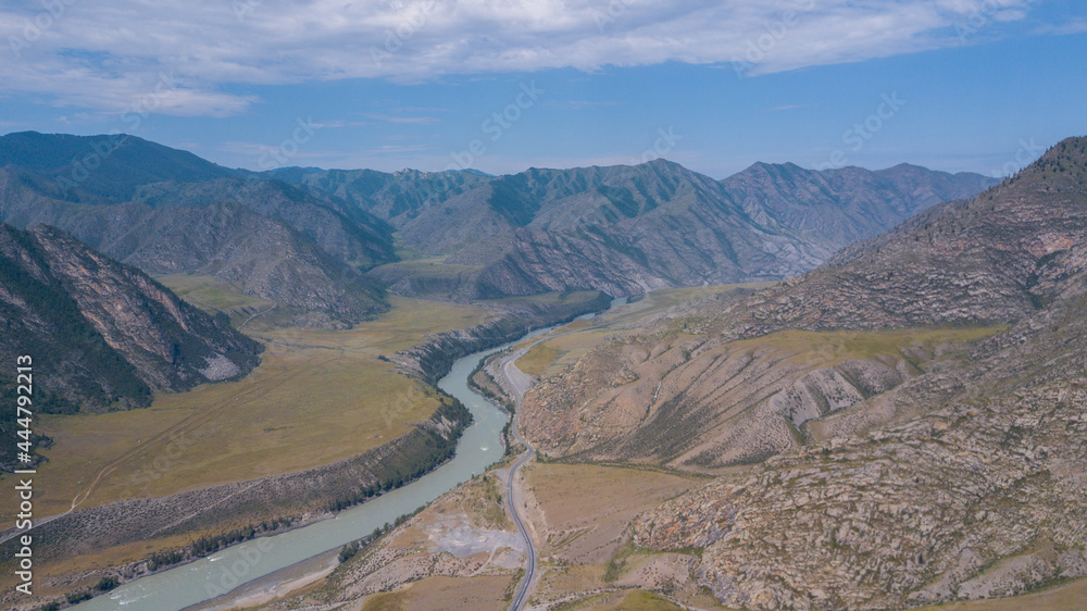 Aerial view of the Katun river flowing in a mountain gorge next to the highway, Altai photo by drone Aerial view of the Katun river flowing in a mountain gorge next to the highway, Altai photo by drone