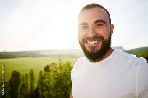 Young bearded man portrait outdoors in the mountains