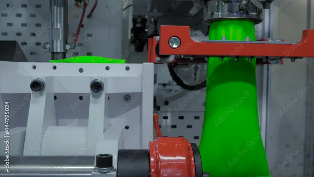 Automatic blow molding machine - manufacturing of empty green plastic jerrycans at factory, exhibition. Industry, packaging, automated technology equipment concept Automatic blow molding machine - manufacturing of empty green plastic jerrycans at factory, exhibition. Industry, packaging, automated technology equipment concept