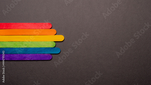 wooden sticks with LGBT rainbow flag on black color background