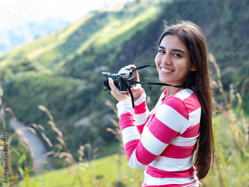 portrait of beautiful latin girl taking pictures with her camera in the mountains of the ecuadorian highlands